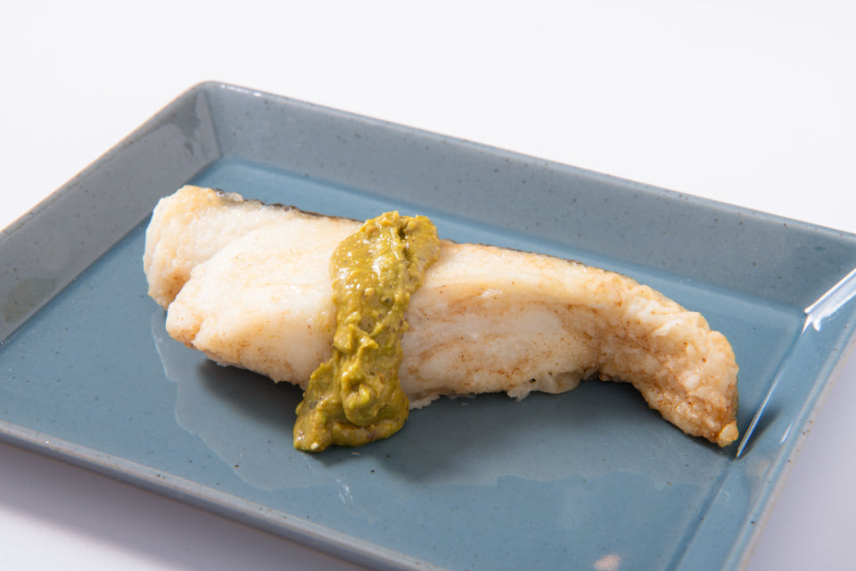 焼いた白身魚の上に、ピスタチオバターで作ったソースをかけた写真