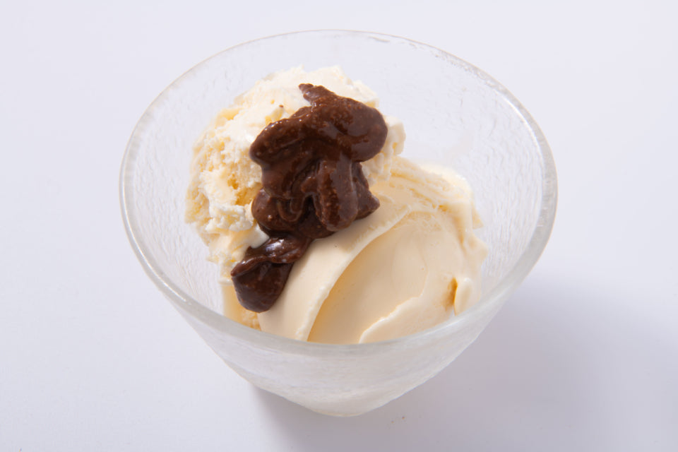 チョコレートアーモンドバターをトッピングしたバニラアイスクリームの写真
